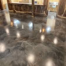 Polished epoxy floor showcasing a sleek, modern design in a rustic setting with wooden accents.