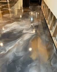 Polished gray and white epoxy floor with swirling patterns in a modern interior space.