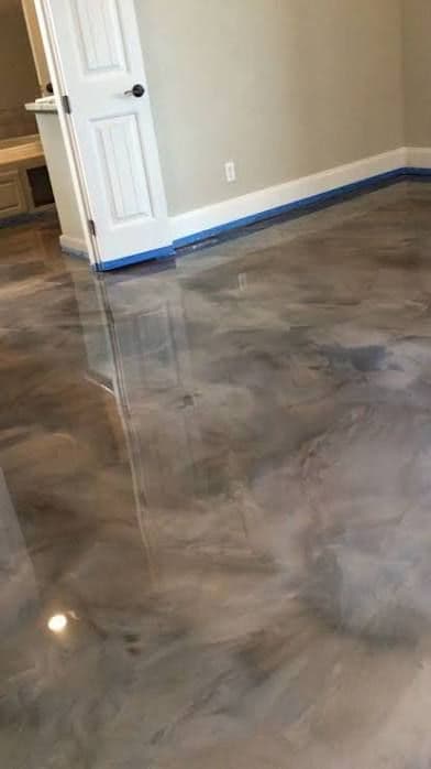 Glossy polished concrete floor in a modern room with blue tape along the wall edges.