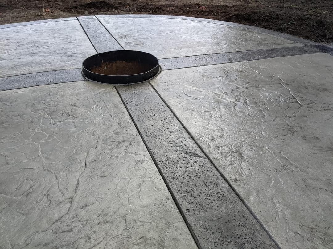Concrete circular slab with a central drain opening and textured surface details.