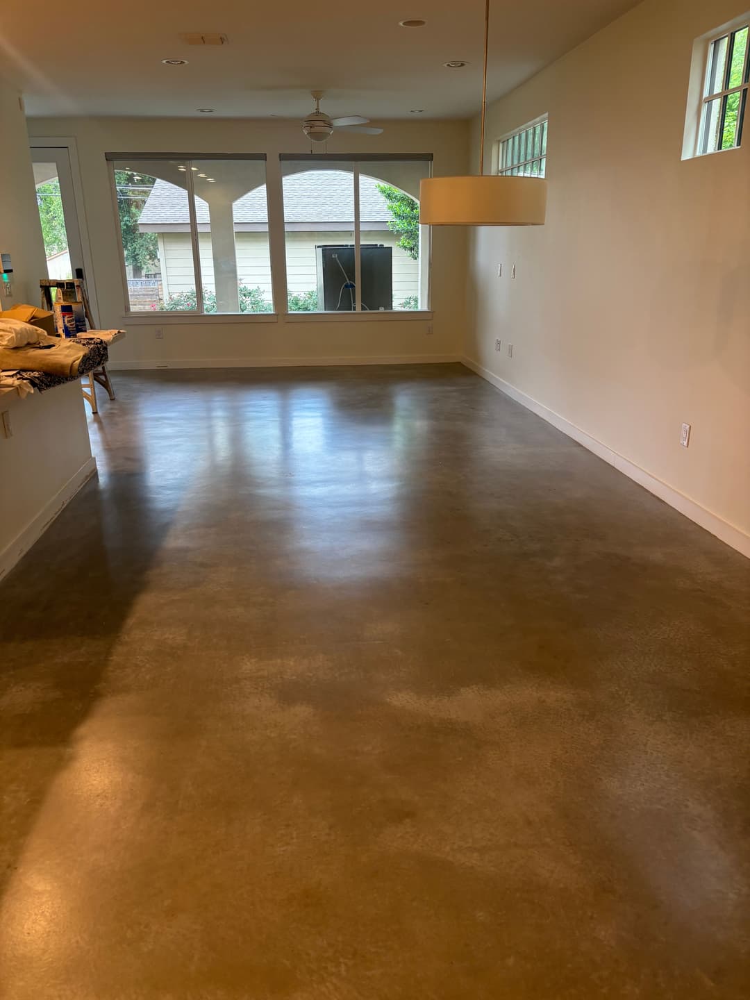 Modern living room with polished concrete floor and large windows for natural light.