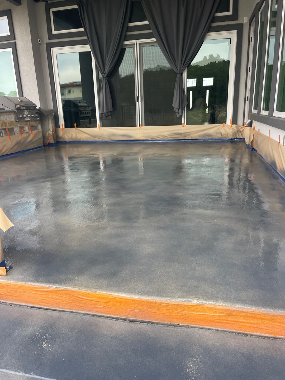 Modern outdoor patio with freshly finished concrete floor and protective coverings.