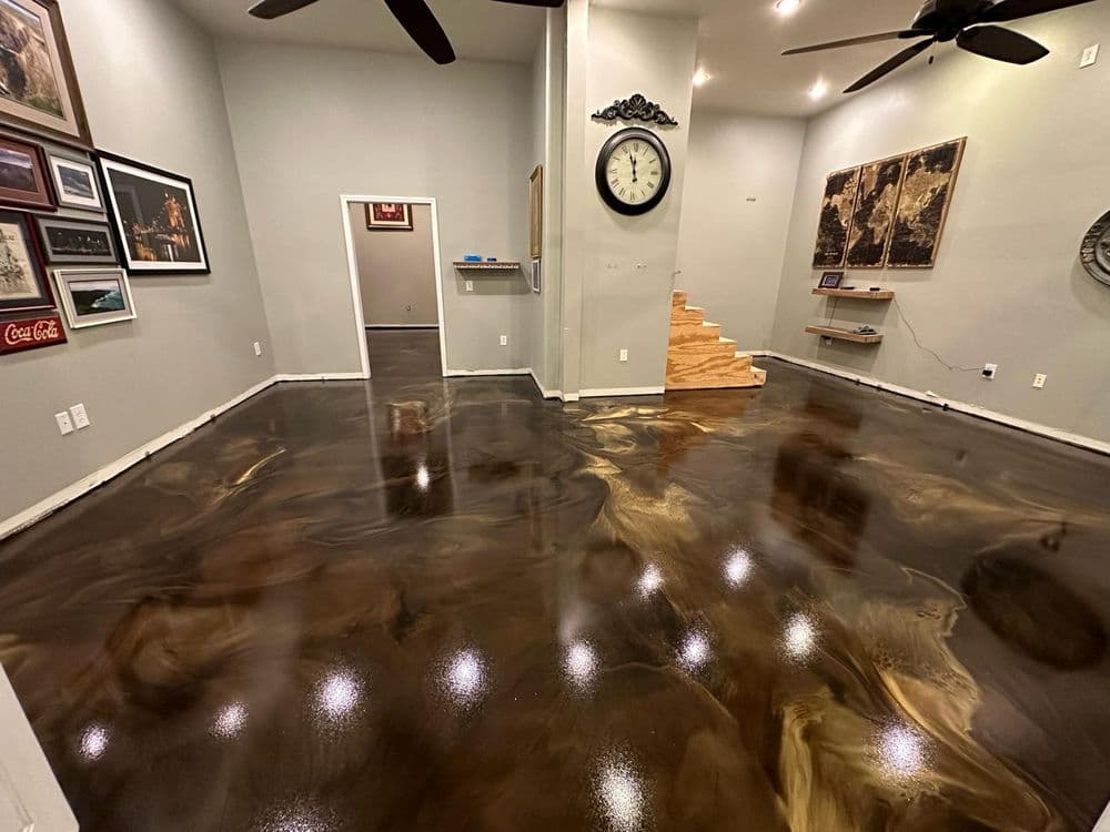 Modern interior with polished epoxy floor, gray walls, clocks, artwork, and wooden stairs.