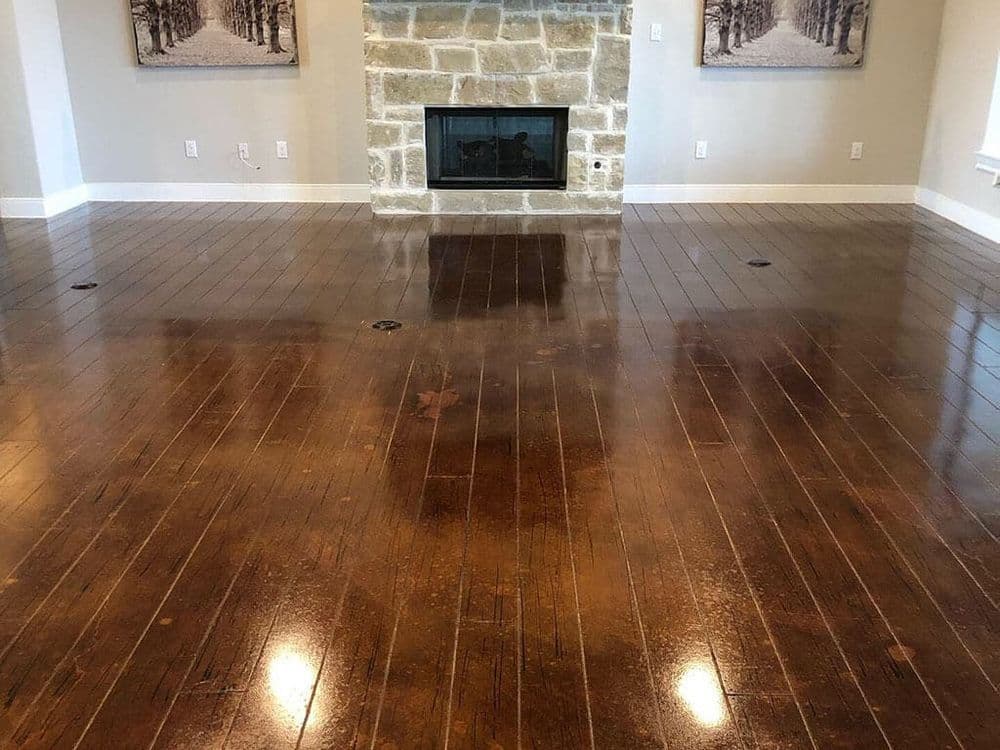 Modern living room with polished brown hardwood floors and a stone fireplace.